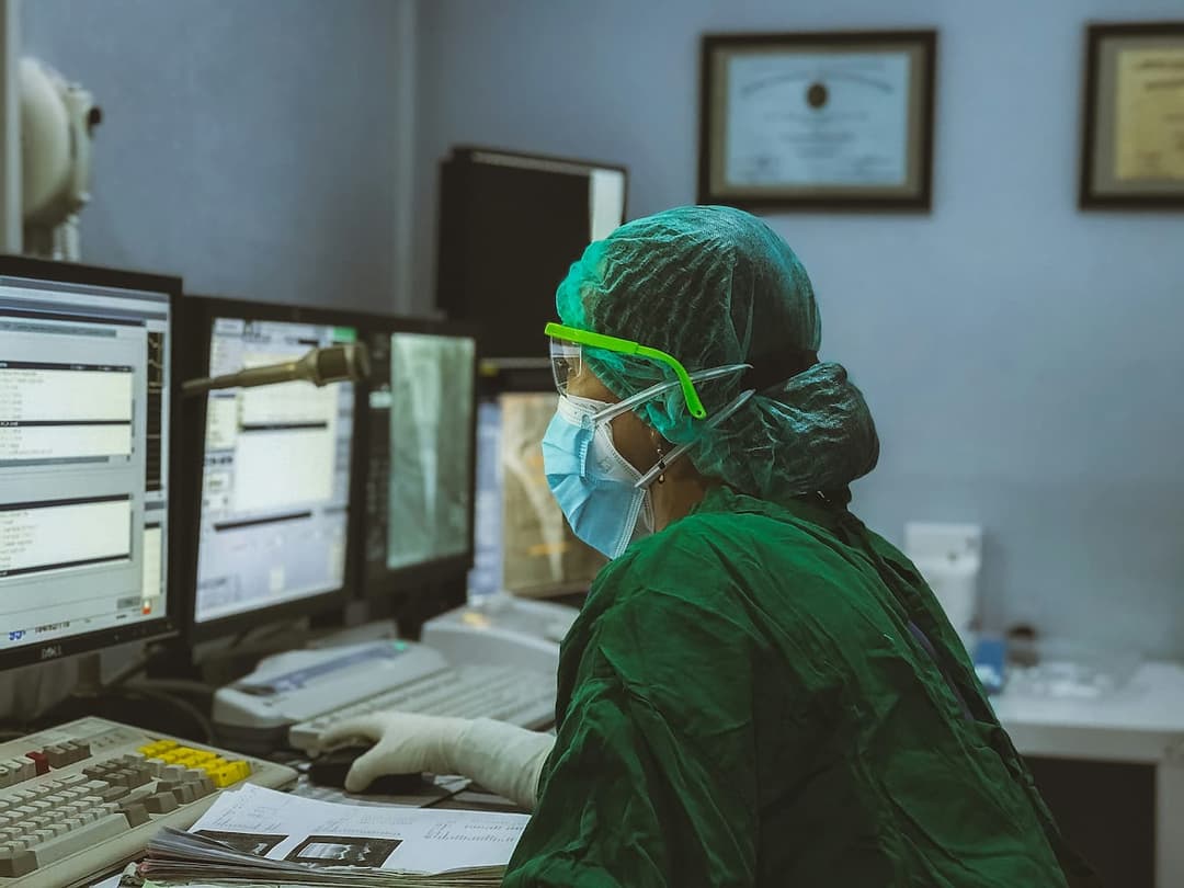 Healthcare professional working on a computer.